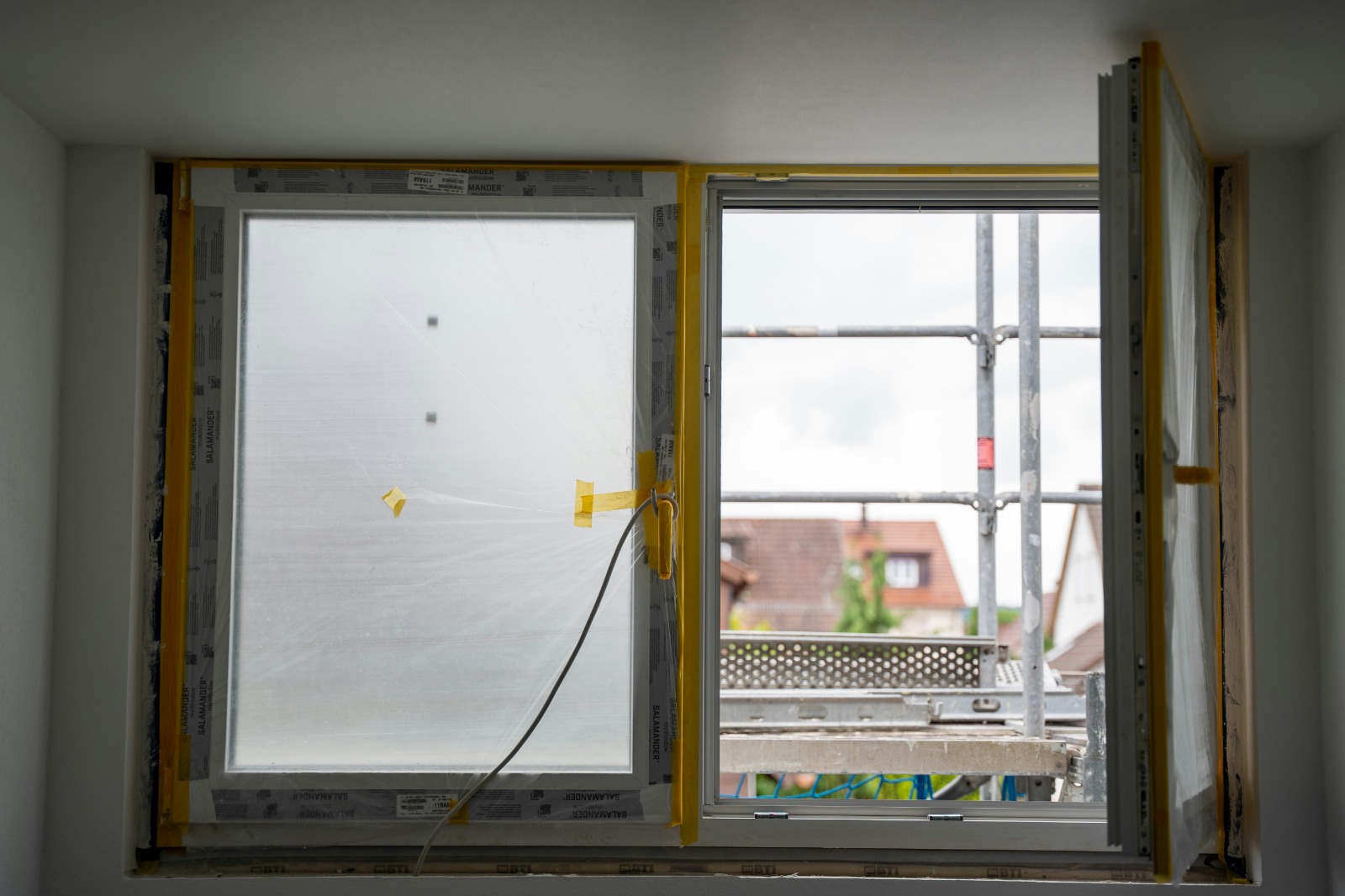 Neu eingebaute Fenster während der Montage, noch mit Schutzfolie und Klebeband